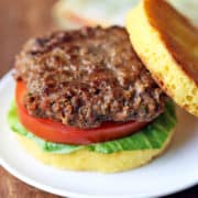 Bison burger is served in a bun with lettuce and tomato.