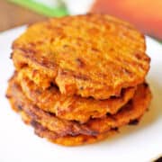 Sweet potato cakes are stacked on a white plate.