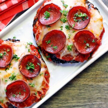 Portobello pizza is served on a white platter with a napkin.