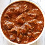 Slow cooker goulash is served in a white bowl.