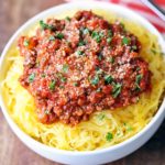 Spaghetti squash with meat sauce is served in a white bowl.