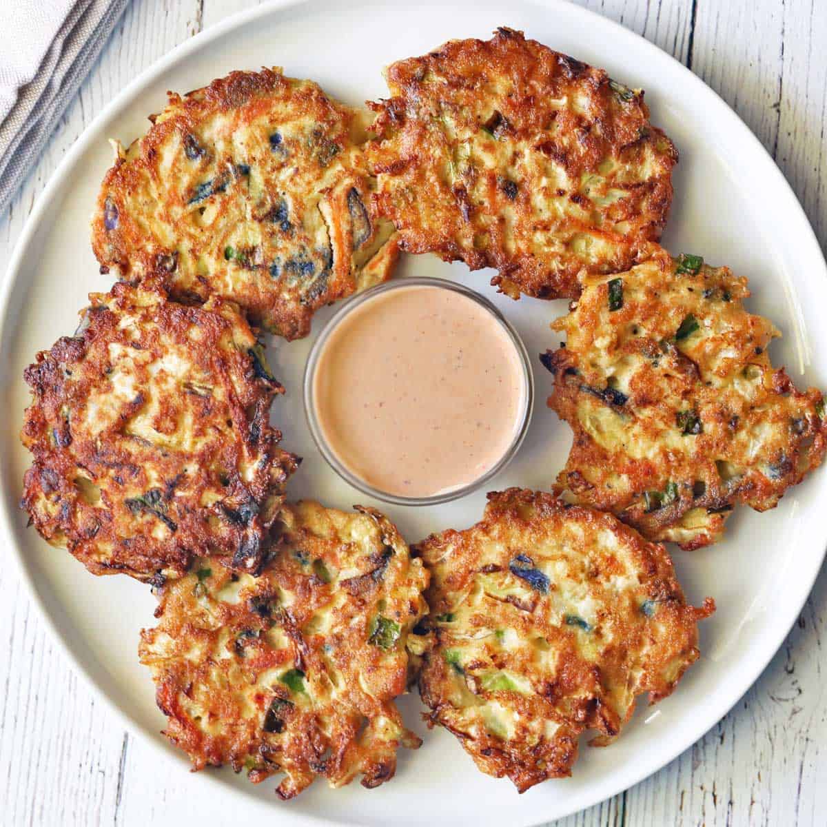 Cabbage pancakes are served with a dipping sauce.
