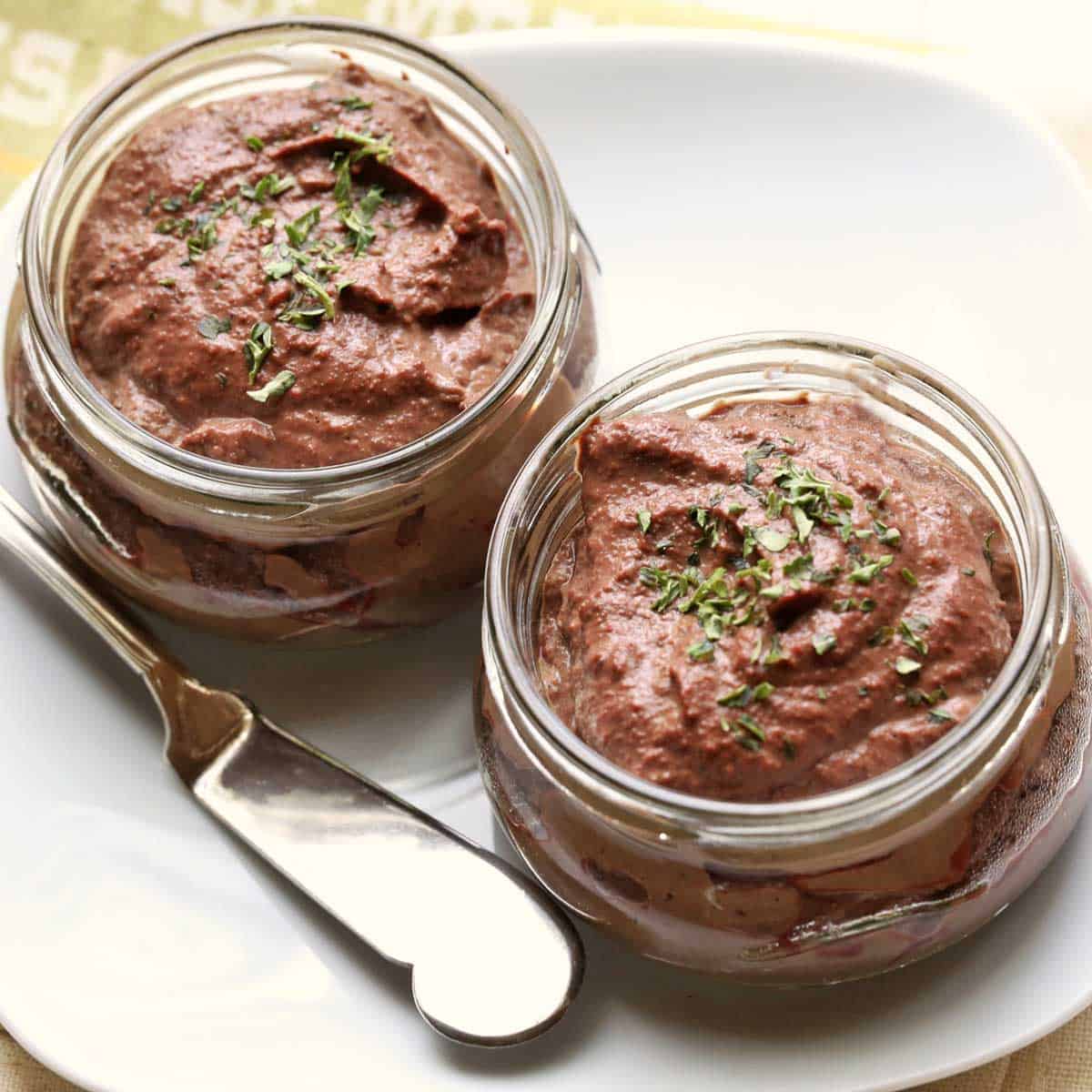 Olive oil chicken liver pate is served in glass containers.