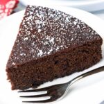 Almond flour chocolate cake is served with a fork.