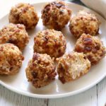Cheese balls are served on a white plate.