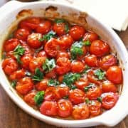 Roasted cherry tomatoes are served in a baking dish.