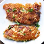 Keto parmesan chicken tenders are served on a white plate.