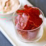 Salami chips are served with a dip.