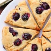 Keto scones with blueberries are served on a white plate.
