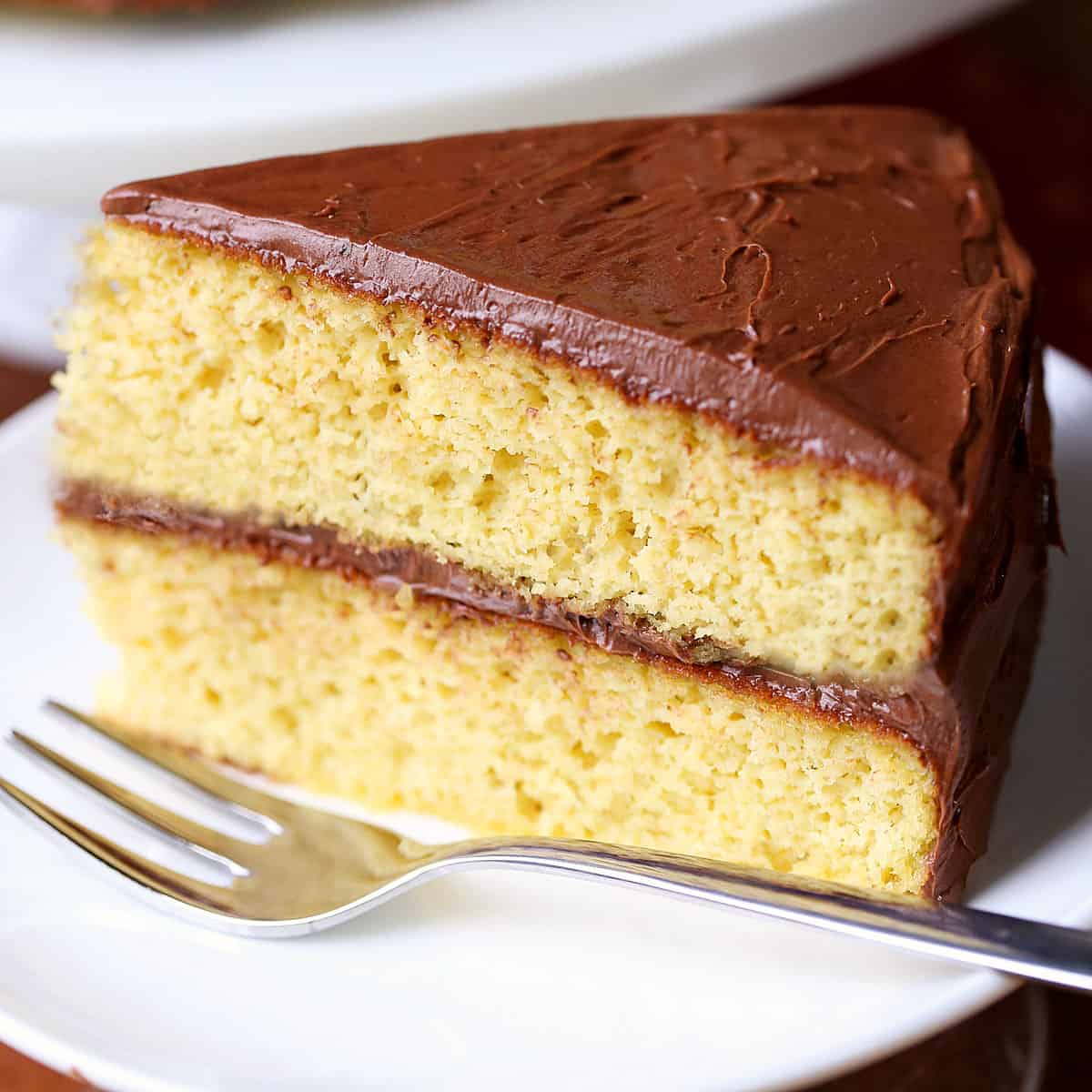 Keto birthday cake is served on a white plate with a fork.