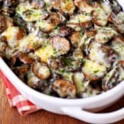 Mushroom casserole is served in a white baking dish with a napkin.