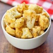 Cauliflower mac and cheese is served in a white bowl with a napkin.