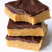 Keto peanut butter bars are stacked on a white plate.