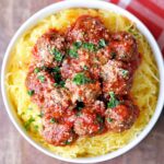 Spaghetti squash and meatballs are served in a white bowl.