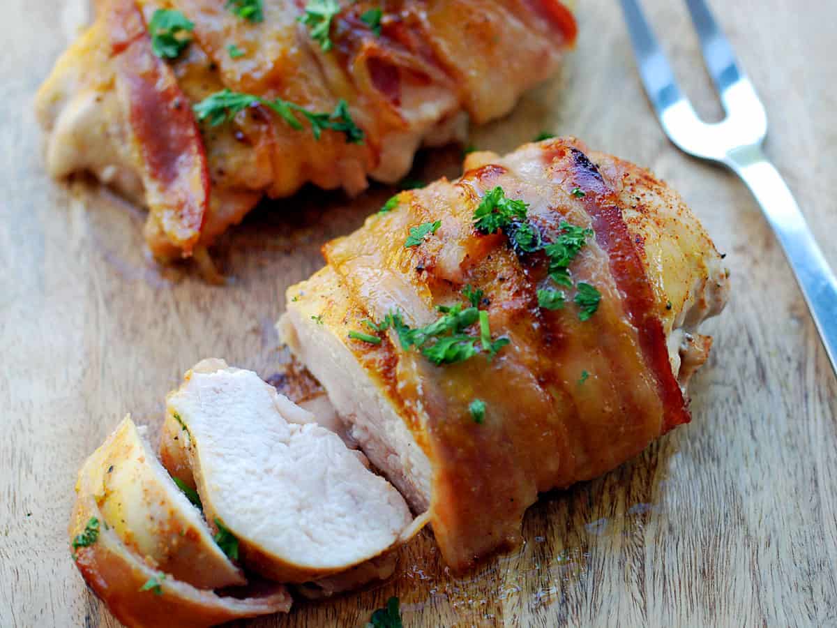 Bacon-wrapped chicken appears white when sliced.