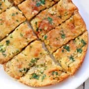 Keto garlic bread is served on a white plate.