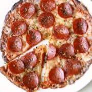 Cauliflower pizza crust is topped with cheese and pepperoni.