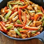 Chicken fajitas are served in a cast-iron skillet.