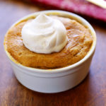 Keto peanut butter mug cake is topped with whipped cream.