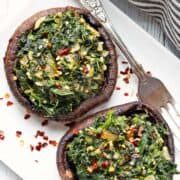 Stuffed portobello mushrooms are served on a white plate.