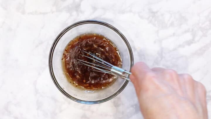 Mixing the dressing in a bowl.