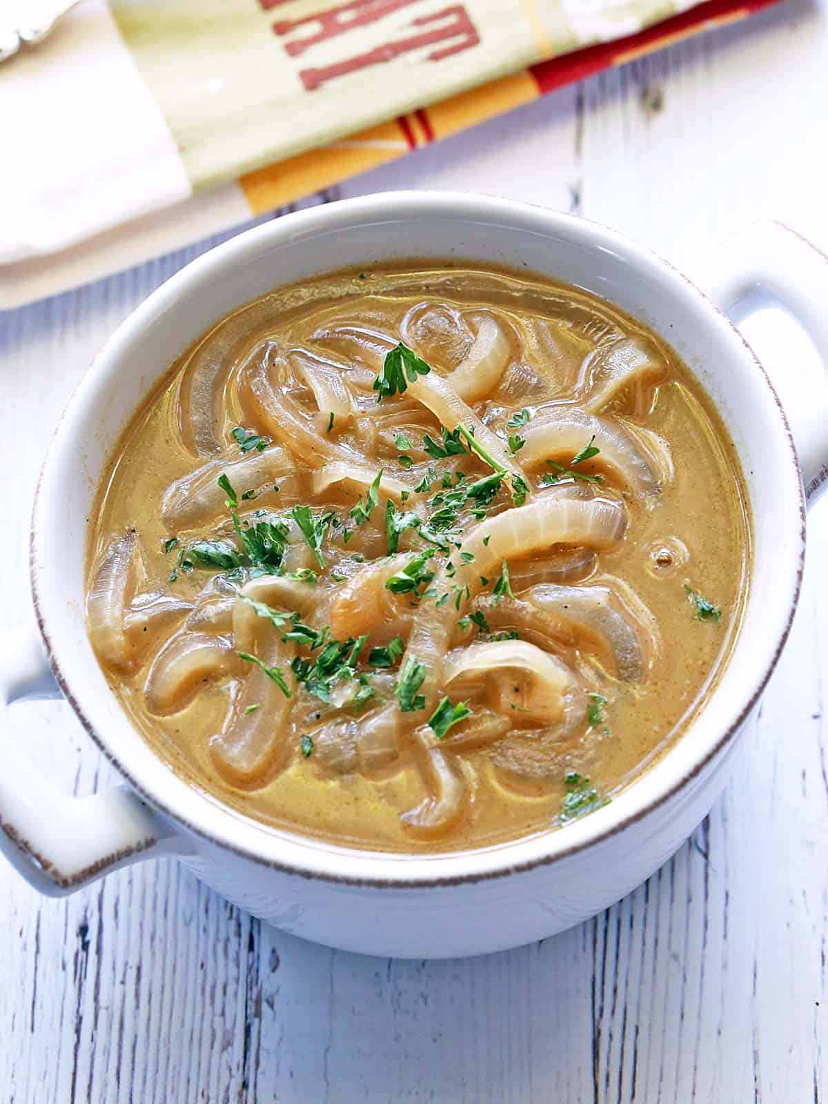 Onion soup is served in a white bowl. 