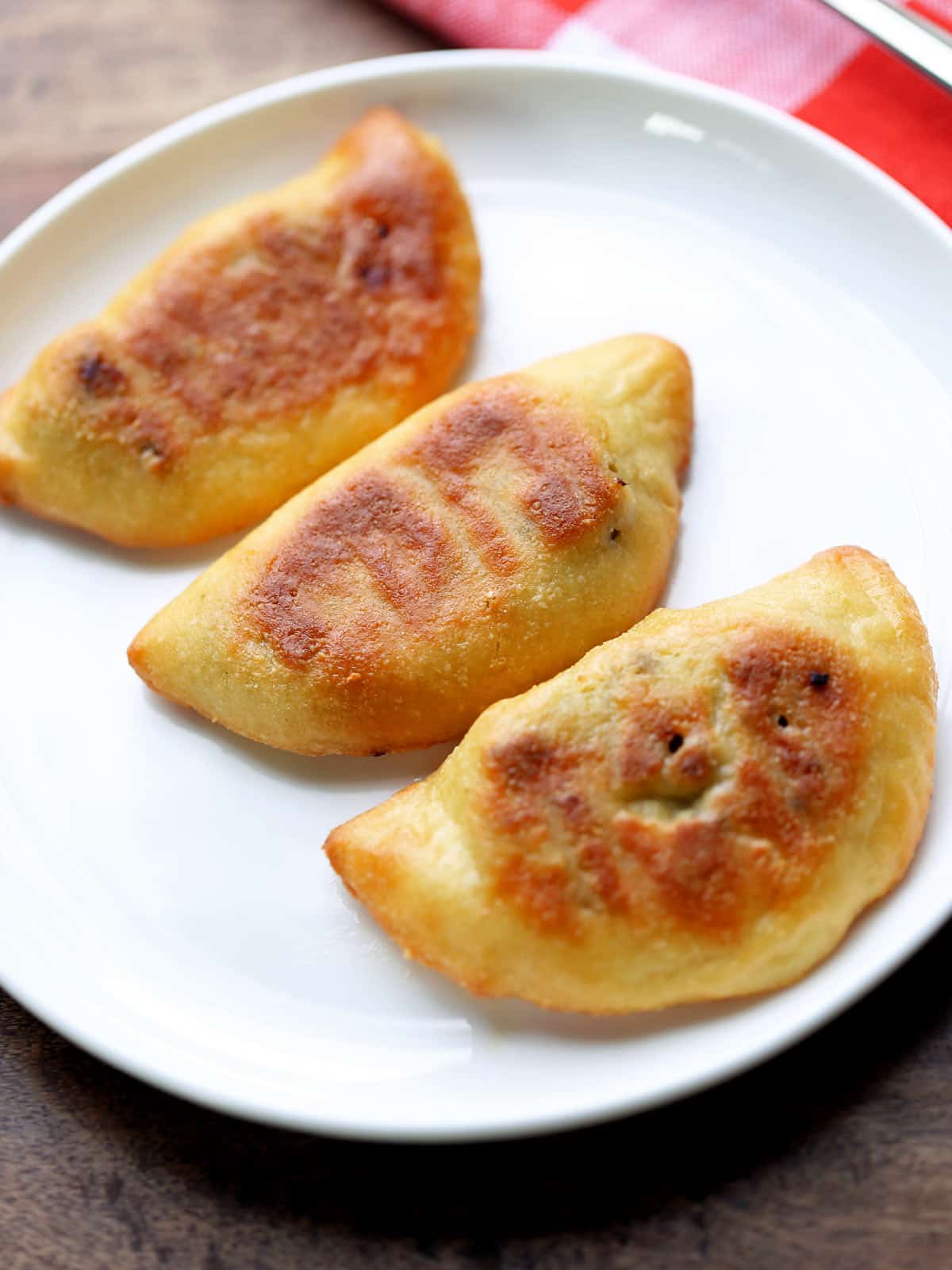 Three keto empanadas are served on a white plate.