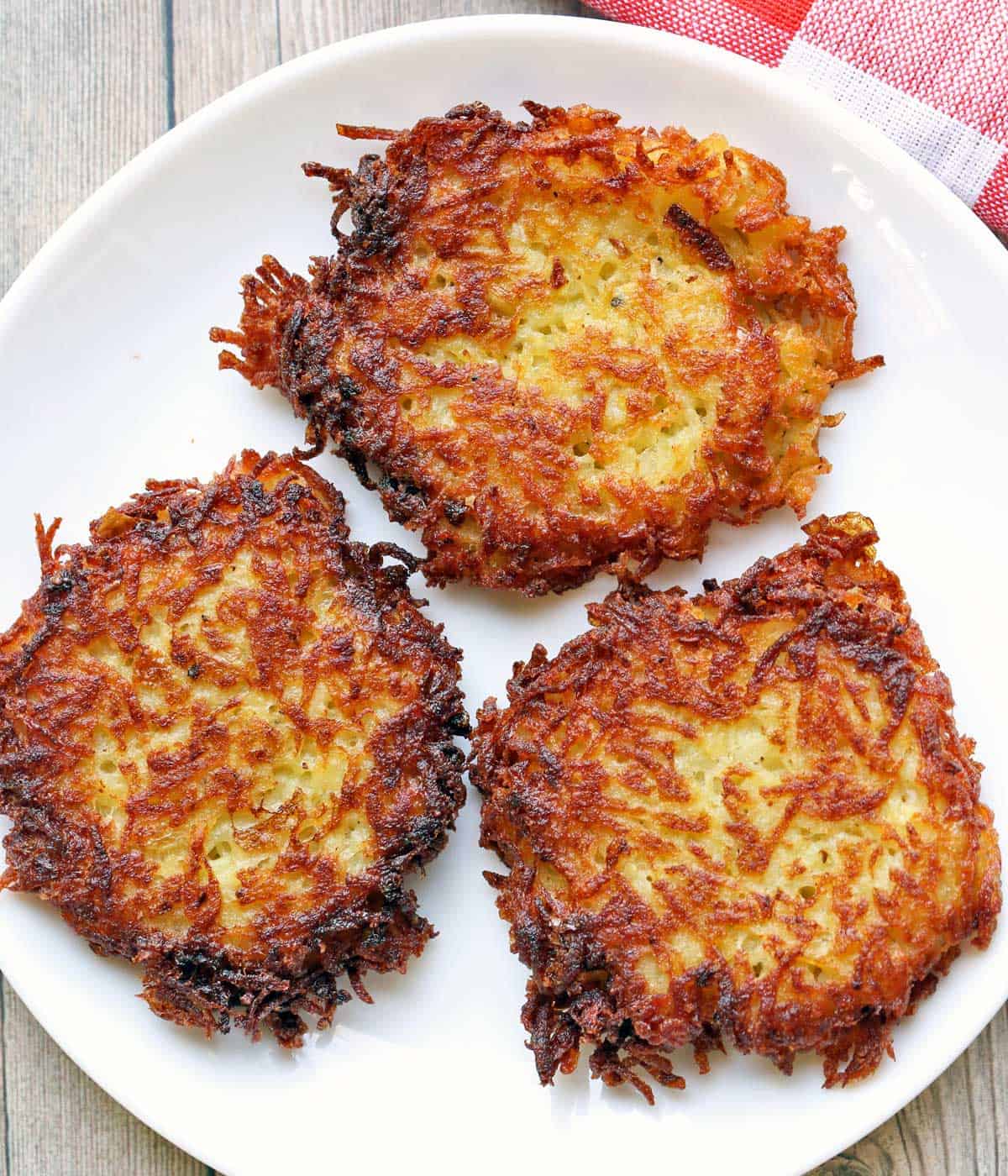 Three latkes served on a white plate.