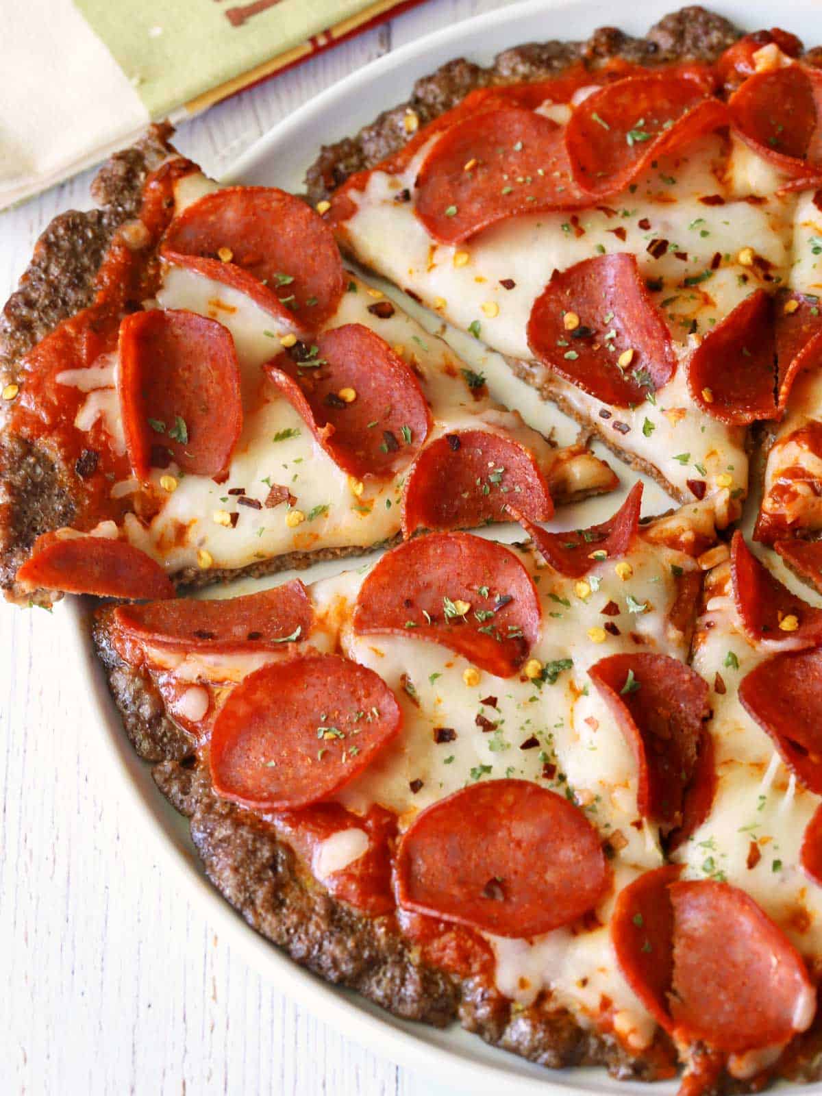 Meatzza is sliced and served on a white plate.