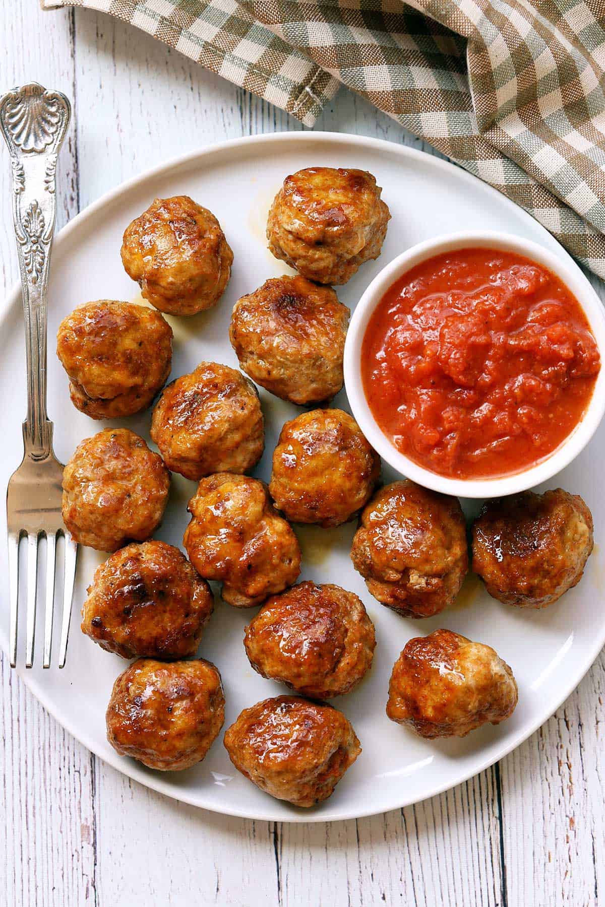 Chicken meatballs are served with a dipping sauce.