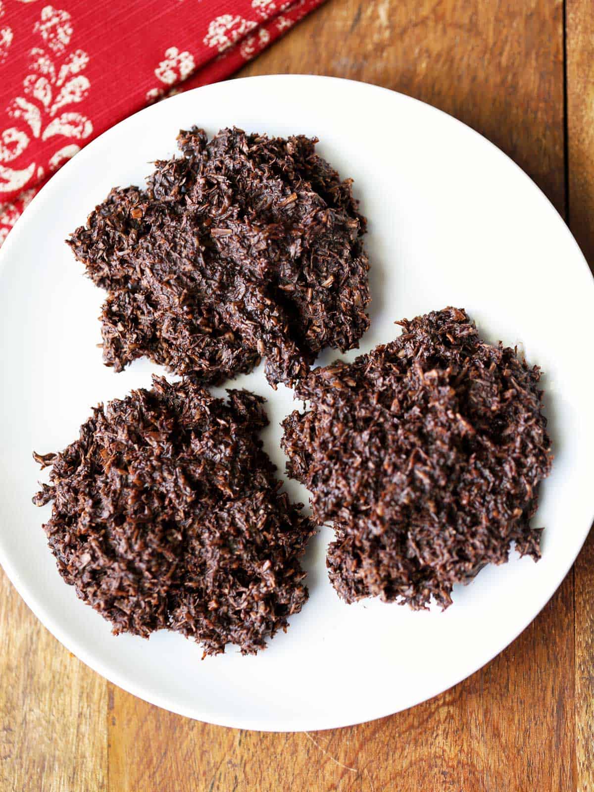 Three coconut haystacks are served on a white plate. 