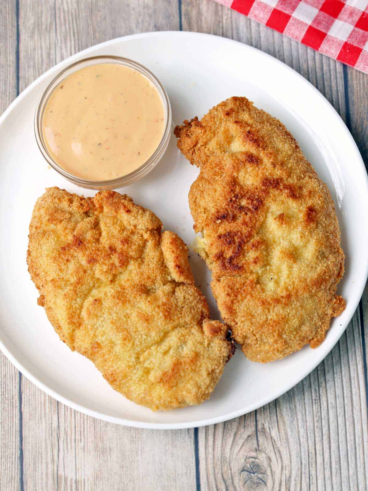Gluten free chicken tenders are served with a dipping sauce. 