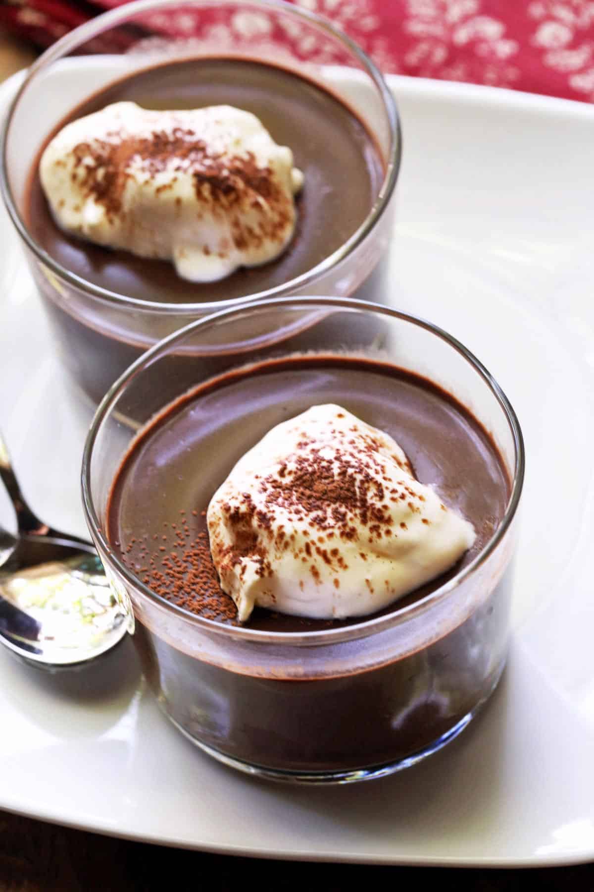 Keto pudding is served in two dessert glasses with spoons. 