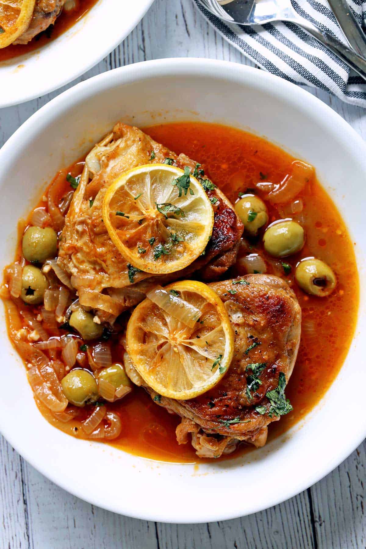 Moroccan chicken served in a bowl with soup spoons.