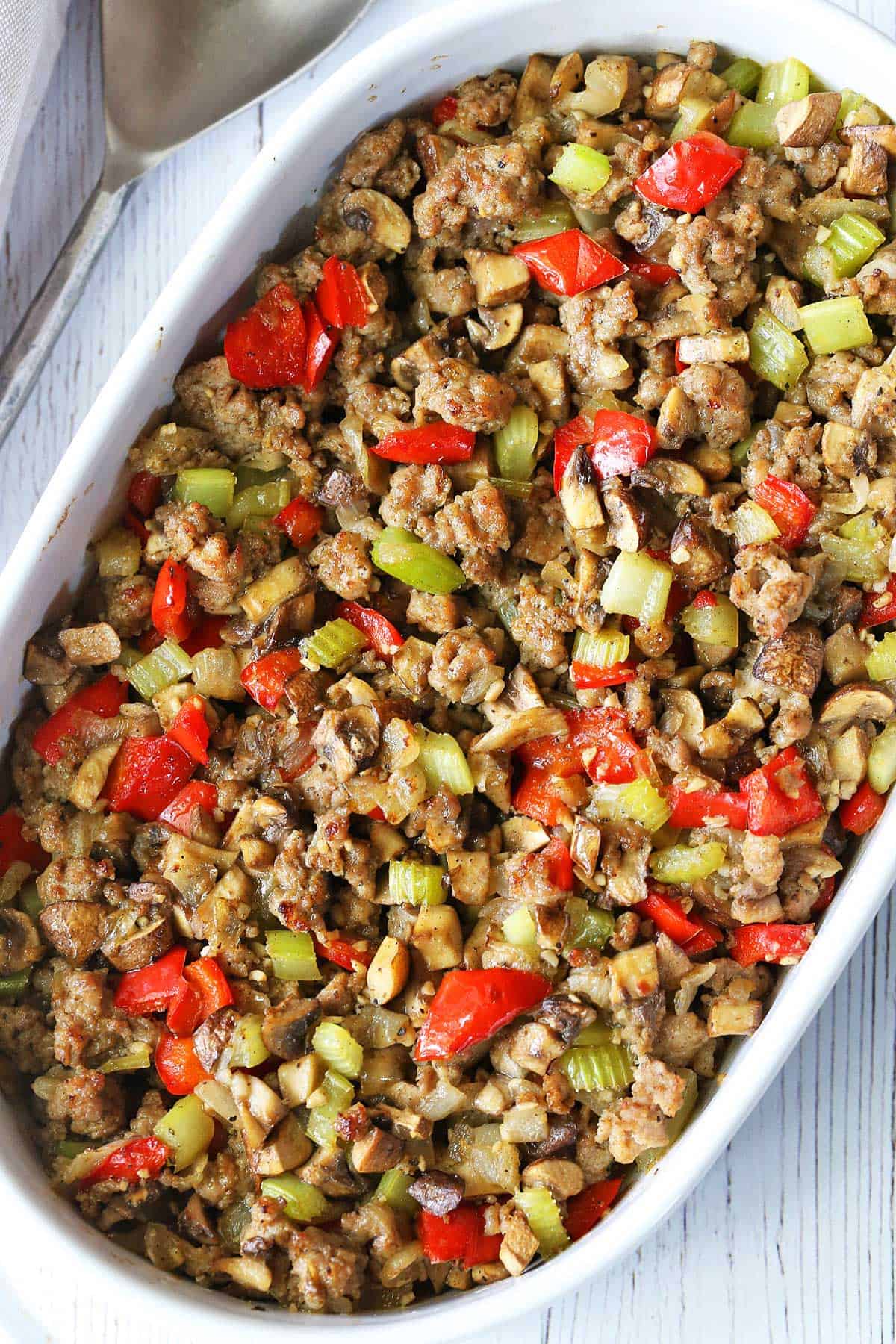 Sausage stuffing is served in a white baking dish.