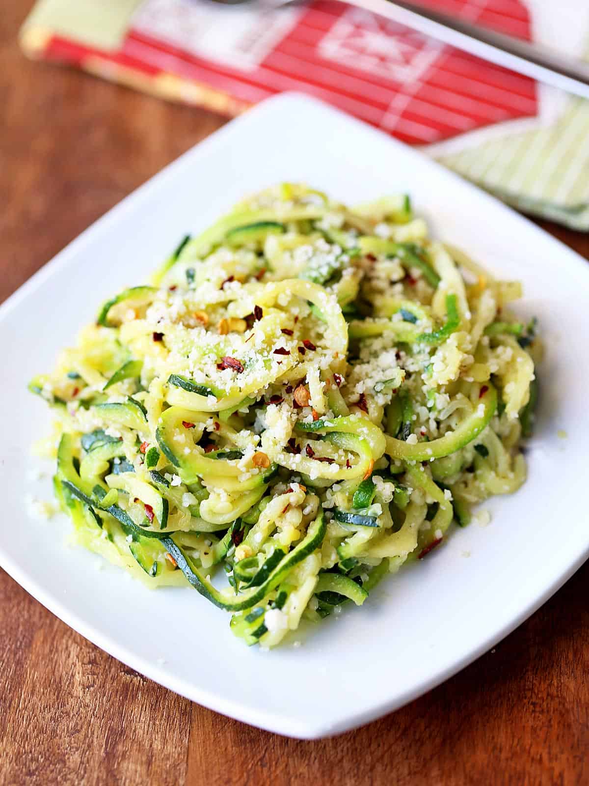 Zucchini noodles are served on a white plate.