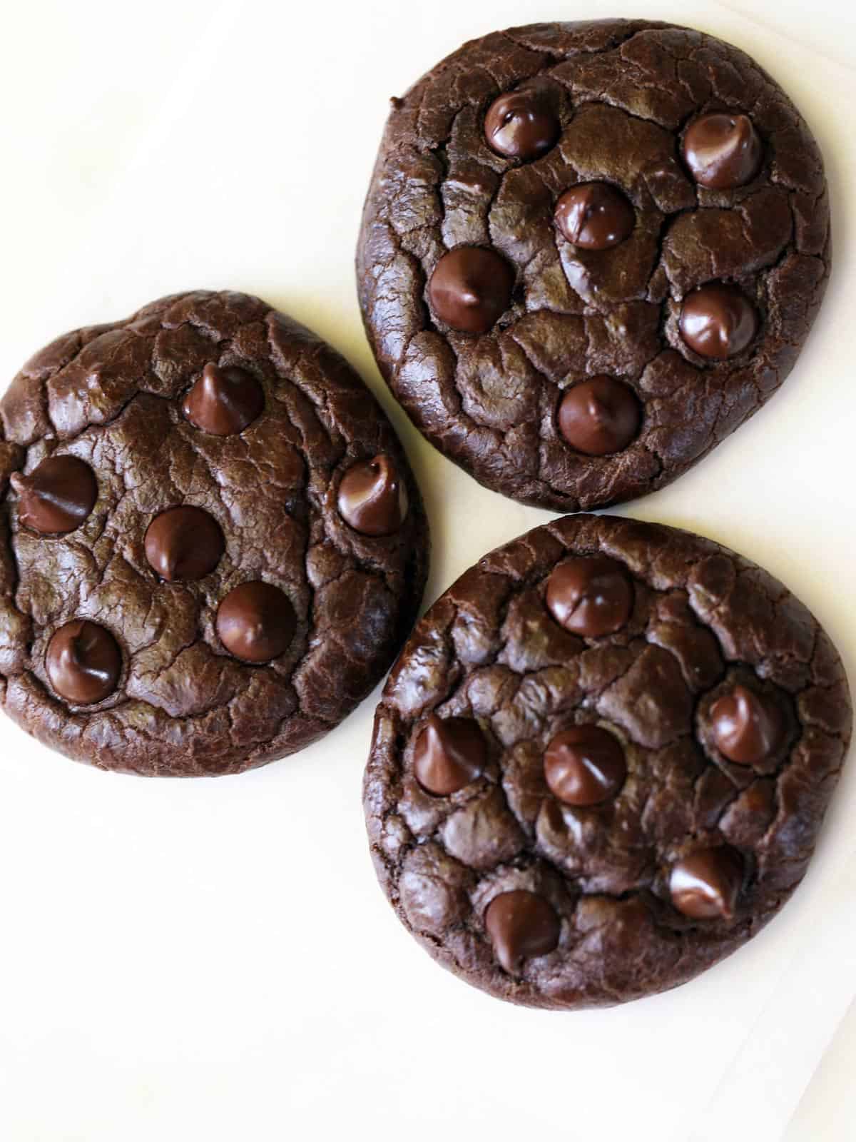 Three keto chocolate cookies are served on a white plate.
