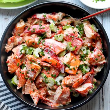 Lobster salad is served in a dark bowl.