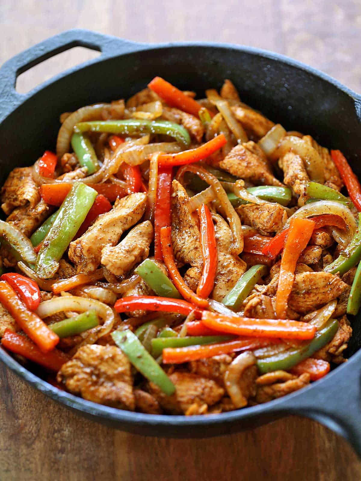 Chicken fajitas are served in a cast-iron skillet. 