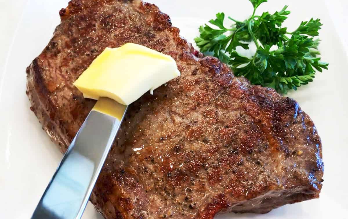 The steak is ready and is topped with butter.