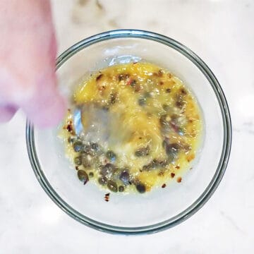 Adding capers to the butter sauce.