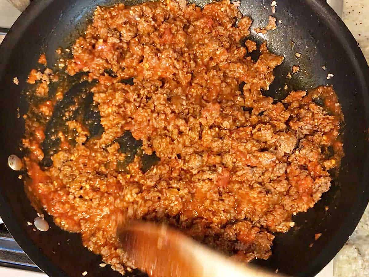 Cooking the beef for zucchini lasagna in a skillet.