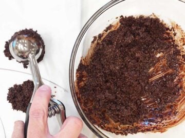 Dropping mounds of the coconut-chocolate mixture onto wax paper.