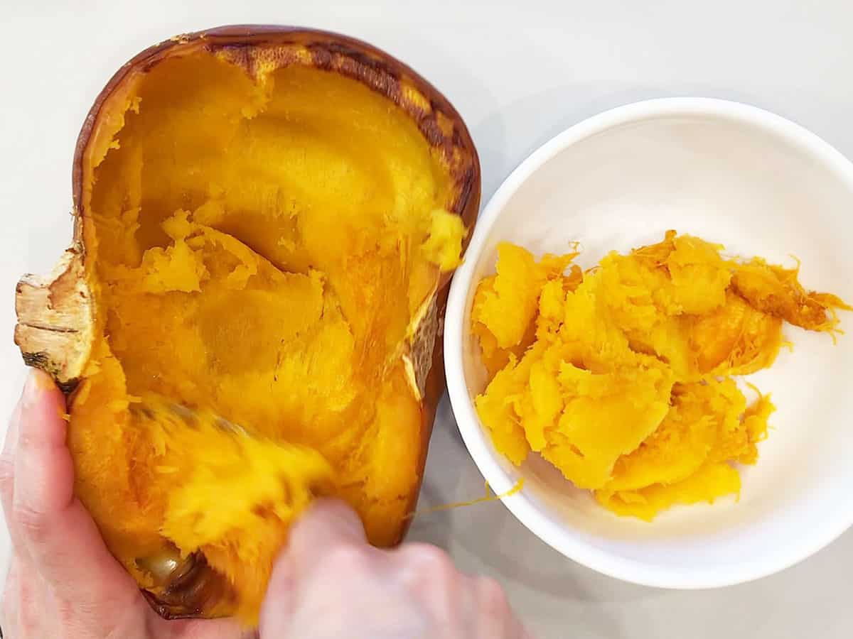 Removing the pumpkin flesh to a bowl.