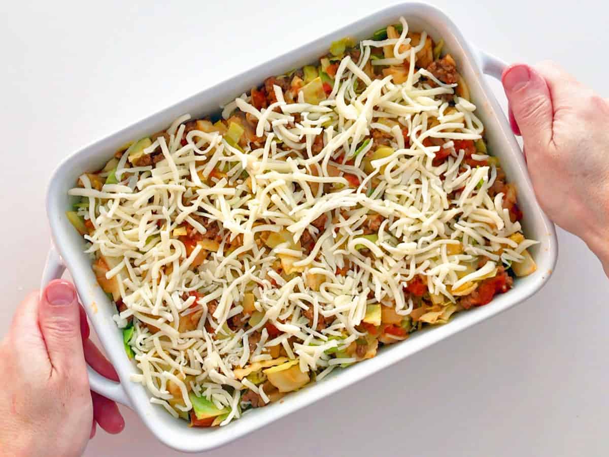 The cabbage casserole is ready for the oven in a baking dish.