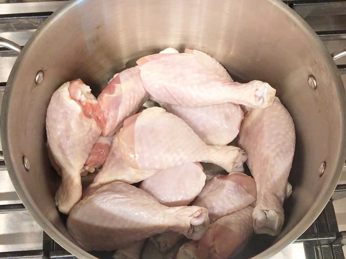 Chicken drumsticks in stockpot.