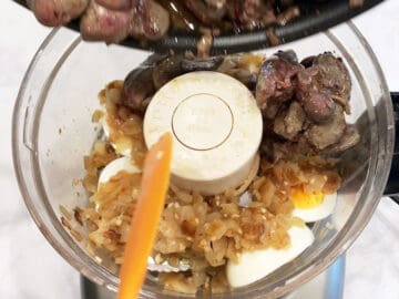 Adding the cooked livers to the food processor.
