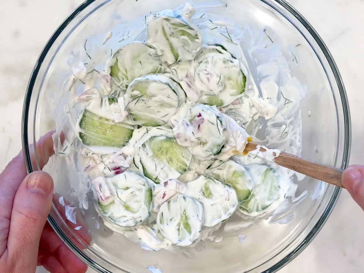 Mixing the vegetables and dressing.