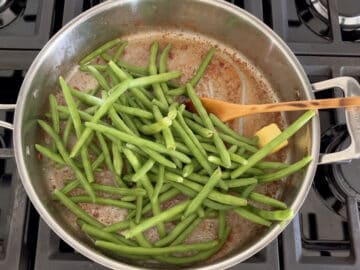 Adding the green beans to the skillet.