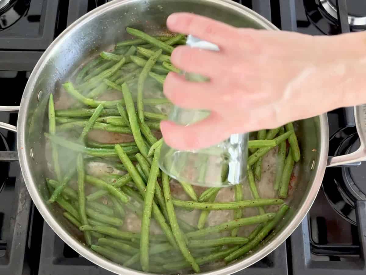 Adding water to the skillet.